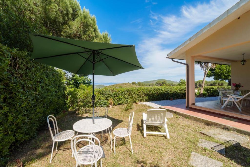 un tavolo e sedie con ombrellone in cortile di Villa Campo al Pero a Rio Marina
