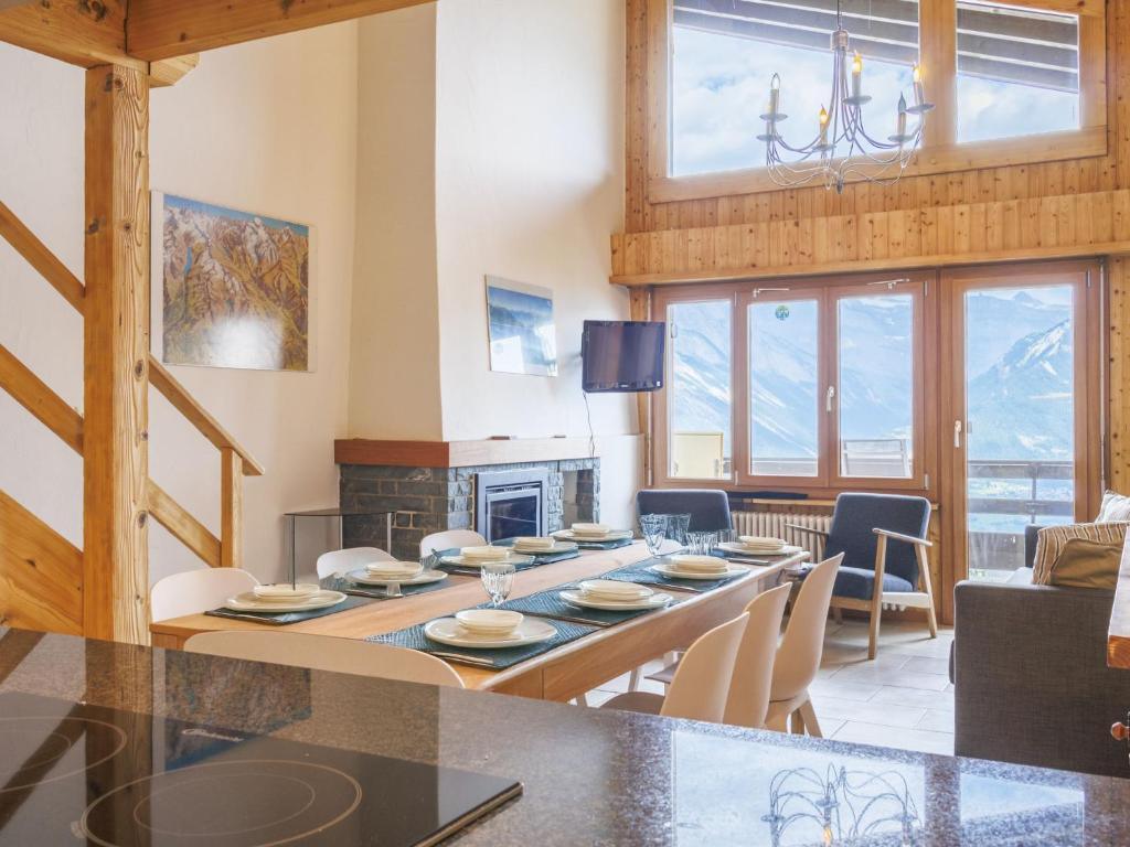 uma sala de jantar e sala de estar com uma mesa e uma lareira em Apartment Bietschorn 22 by Interhome em Nendaz