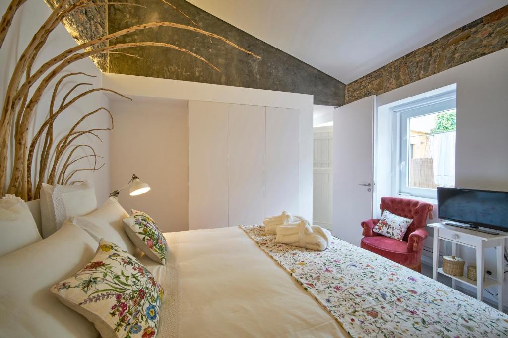 a bedroom with a large bed and a tv at Sparrow Sintra Nest in Sintra