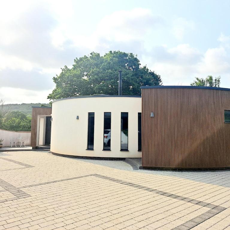 a white building with black windows and a brown wall at The Shutter House in Compton