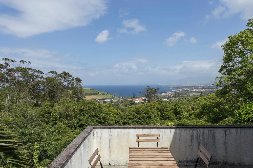a bench sitting on top of a concrete wall at Casa do Maranhão - Nature & Views Experience in Capelas