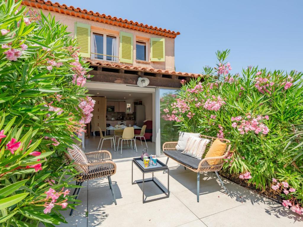 un patio avec des chaises, une table et des fleurs dans l'établissement Holiday Home Les Bastides de Guerrevieille-7 by Interhome, à Sainte-Maxime