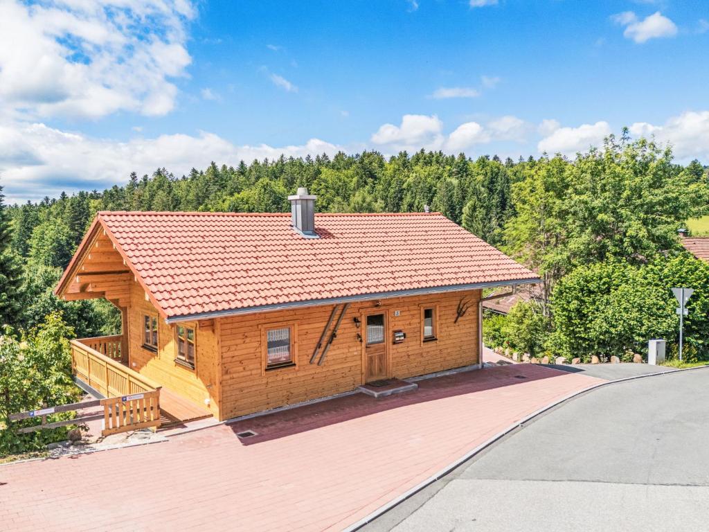 a log cabin with a roof on a driveway at Holiday Home Chalet Toni mit Sauna by Interhome in Spiegelau
