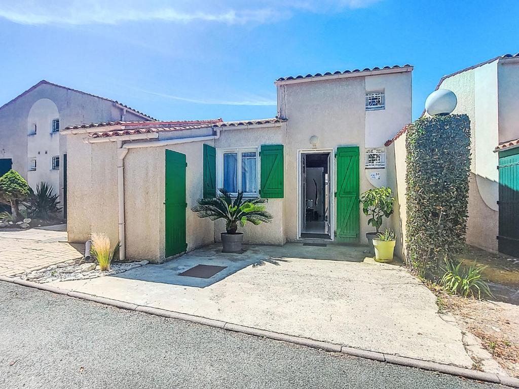 une maison avec des portes vertes dans une rue dans l'établissement Holiday Home Les Conches by Interhome, à Saint-Georges-dʼOléron