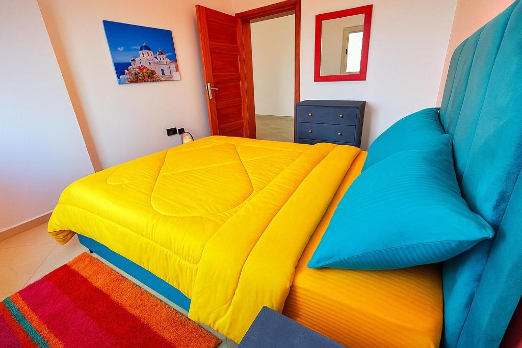 1 dormitorio con 1 cama con edredón amarillo y azul en Charming Two Bedroom Apartment in Fes Near City Center, en Fez
