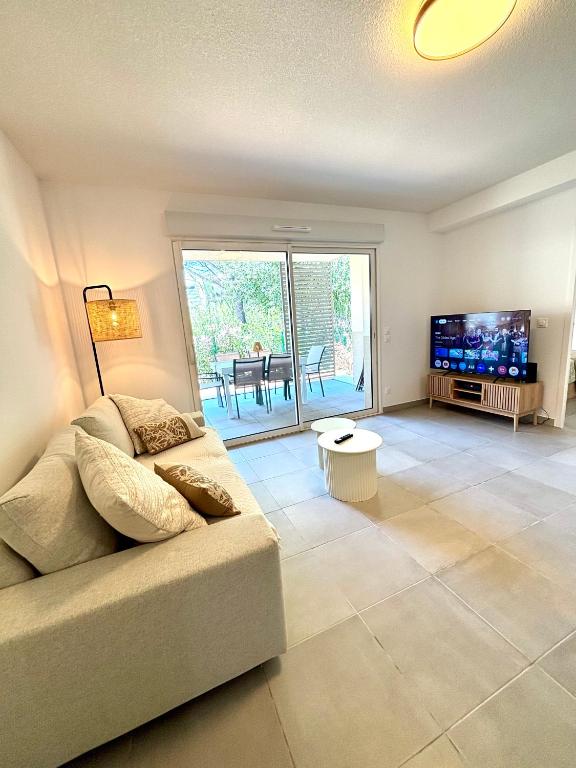 un salon avec un canapé et une télévision dans l'établissement Nice apartment with garden direct access to beach,Parking free, à Vias