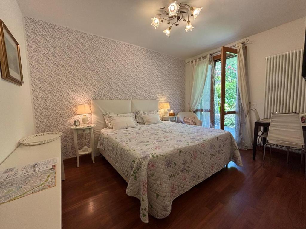 维罗纳Residenza Fontana del Ferro的一间卧室，里面有一张床、两张桌子和一扇窗户