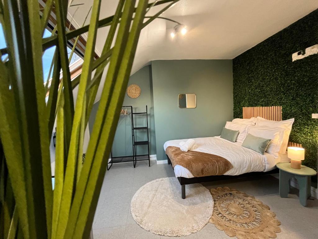 une chambre avec un lit et un mur végétal dans l'établissement Le Verdélite - Studio design & végétal proche gare, à Évreux