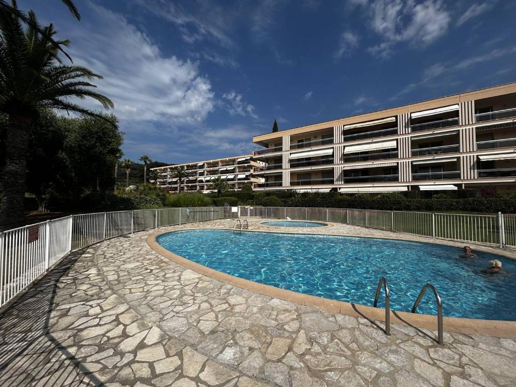 une piscine devant un immeuble dans l'établissement Bel appartement avec terrasse et vue mer à Cavalaire-sur-Mer - FR-1-100-361, à Cavalaire-sur-Mer