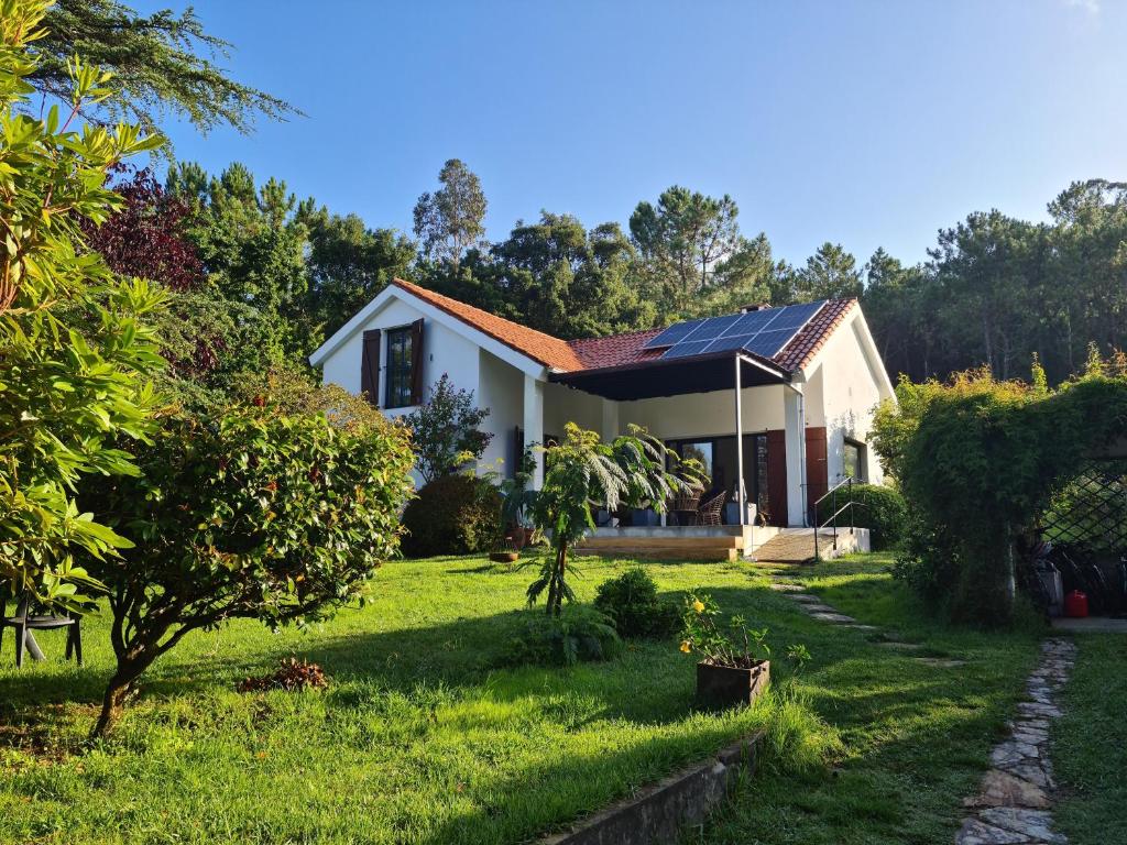 a house with solar panels on the roof at Cottage Playa Cabeiro in Porto do Son