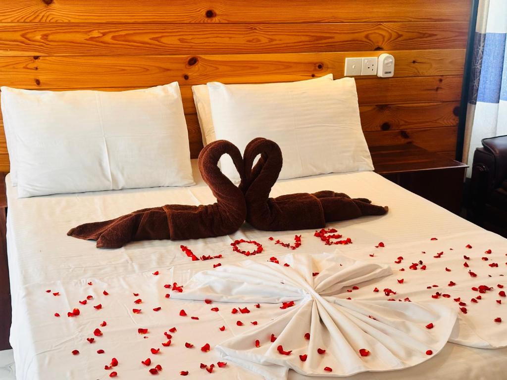 due cigni seduti sopra un letto con il cuore di Rekawa Turtle Gate Hotel a Tangalle