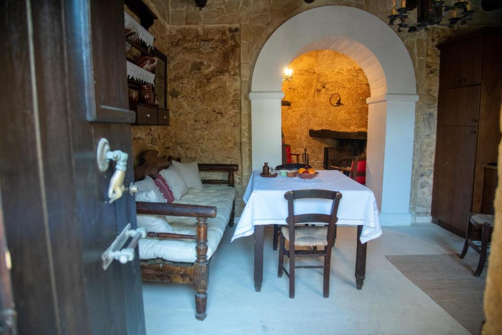 a dining room with a table and chairs in a building at Garofano Traditional House in Melidhónion