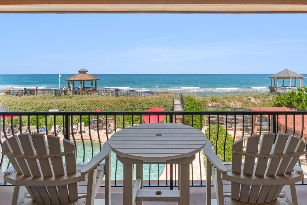 a table and chairs on a balcony with the beach at Sweet Escape in Kill Devil Hills