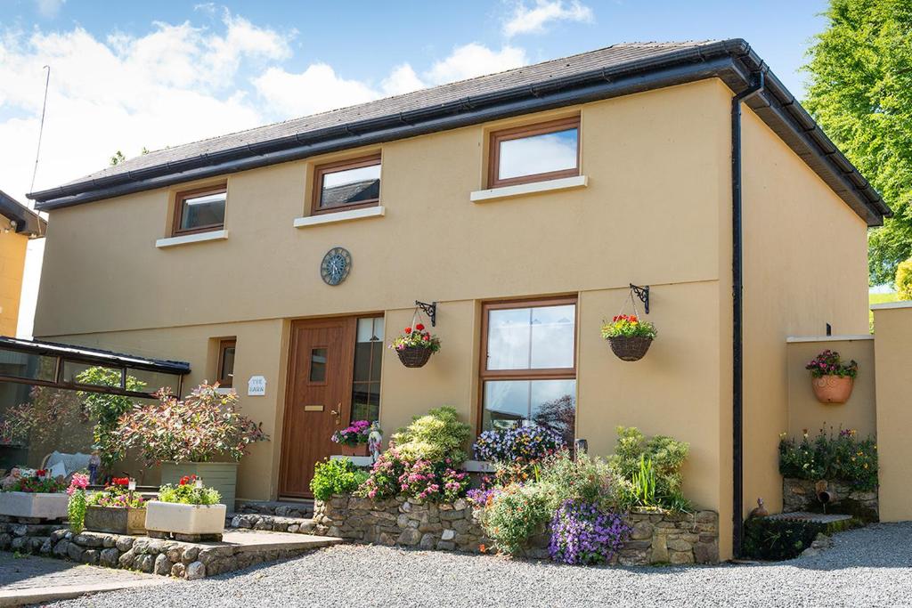 a house with flowers in front of it at Green Meadow Farm Holiday Cottages in Redcross