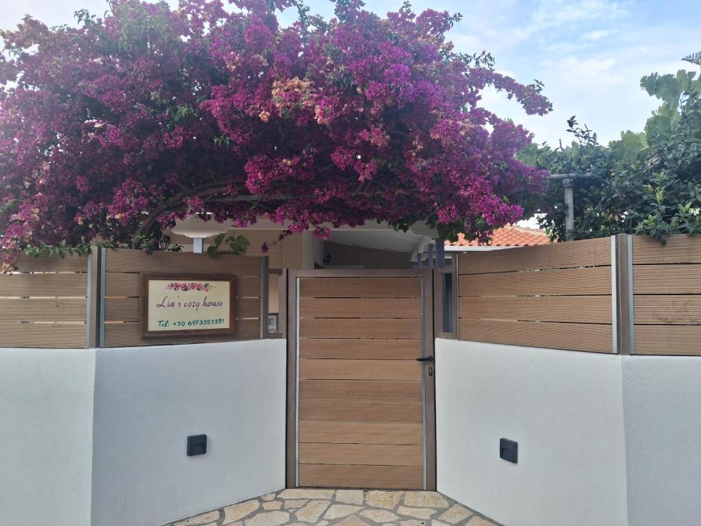 a fence with a gate with pink flowers on it at Lia's Cozy House in Lefkada