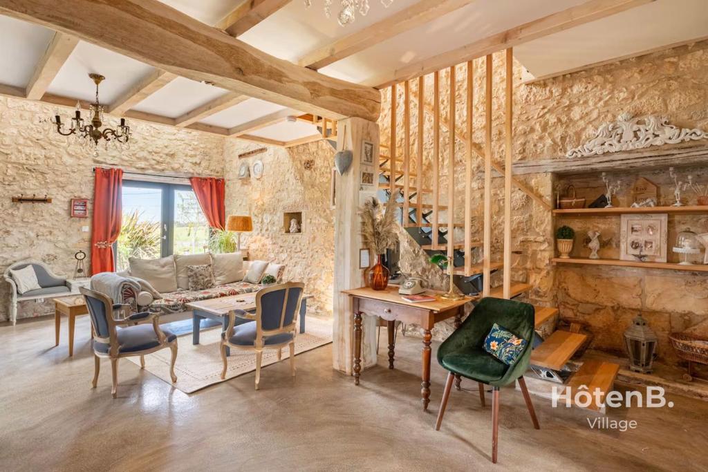 un salon avec un mur en pierre dans l'établissement Douce Campagne Cottage Private Spa, à Blanc