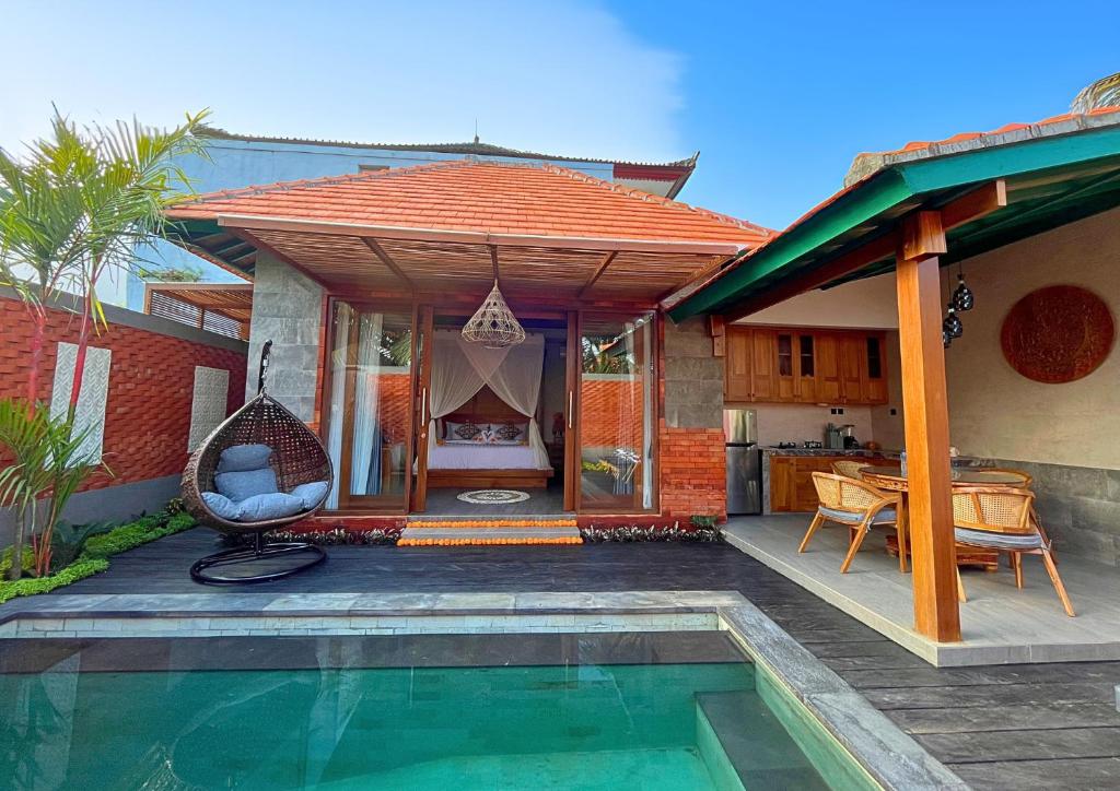 a house with a swimming pool in front of a house at Maharatu Suite Villa in Ubud