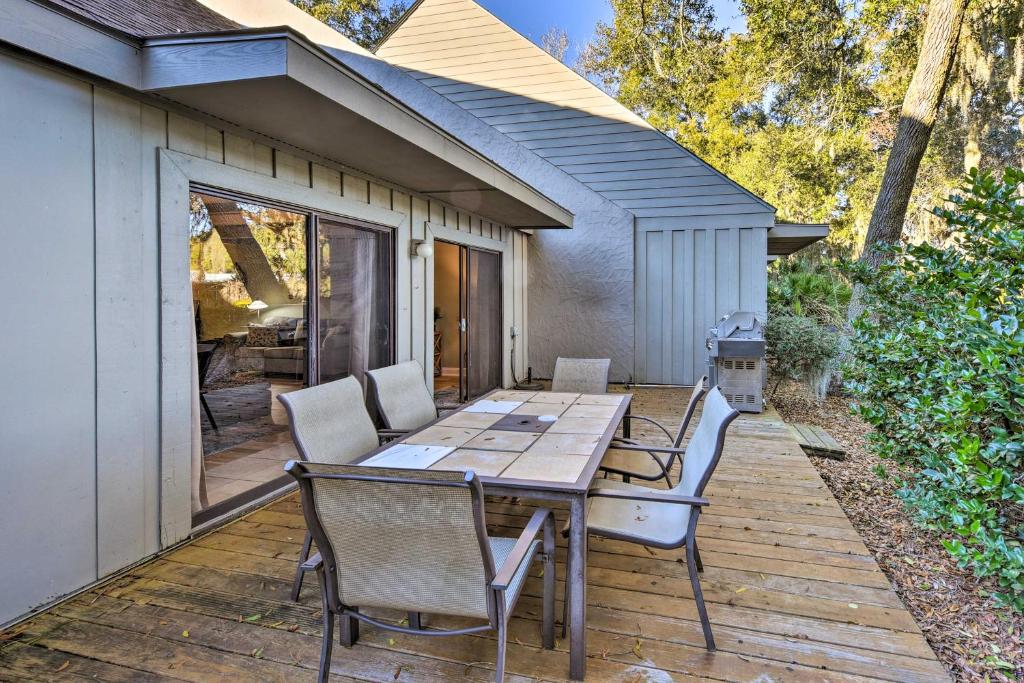 a patio with a table and chairs on a deck at Pool Access and Pet Friendly Condo in Hilton Head in Hilton Head Island