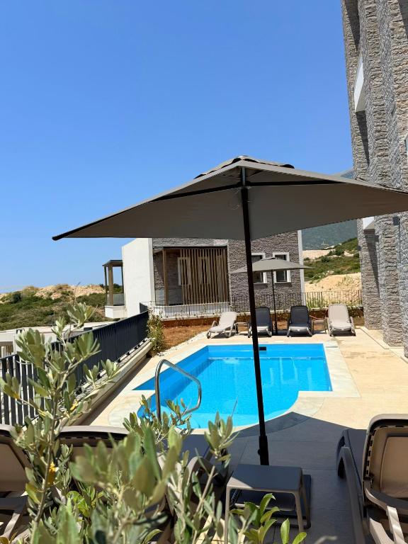 a large umbrella sitting next to a swimming pool at Turquoise Pool Side Thymus Resort in Himare