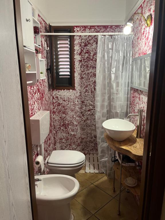 a bathroom with a toilet and a sink at Villa Rosa in Alessano