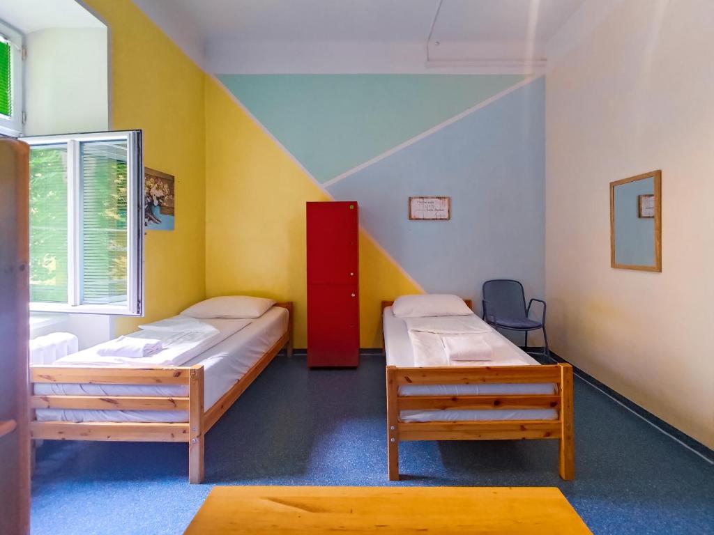 pokój z dwoma łóżkami i schodami w obiekcie Westend City Hostel w Wiedniu