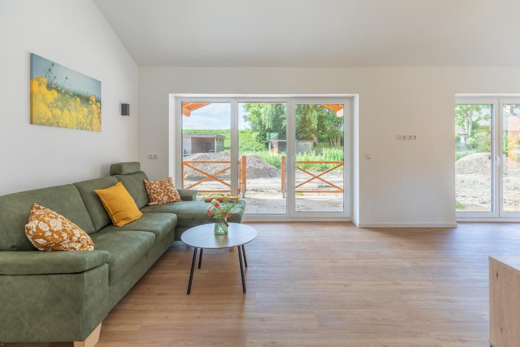 a living room with a green couch and a table at Huus Mullewap in Kating