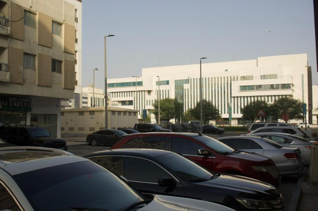 a parking lot with cars parked in front of a building at Downtown Private room in Abu Dhabi
