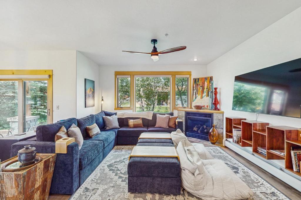 a living room with a blue couch and a fireplace at Moose Crossing at Town Center in Big Sky