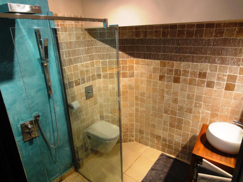 a bathroom with a shower and a toilet and a sink at Les toîts d&#39;Uzès in Uzès