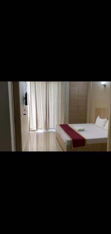 ein kleines Schlafzimmer mit einem Bett und einem Fenster in der Unterkunft Krishna Residency in Vrindāvan