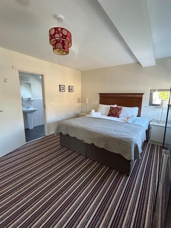 a bedroom with a large bed and a bathroom at 11 The Avenue in Killarney