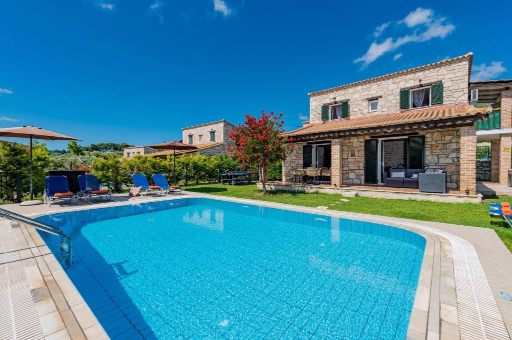 a villa with a swimming pool and a house at Villa Rizolia Enea by Villa Plus in Lithakia