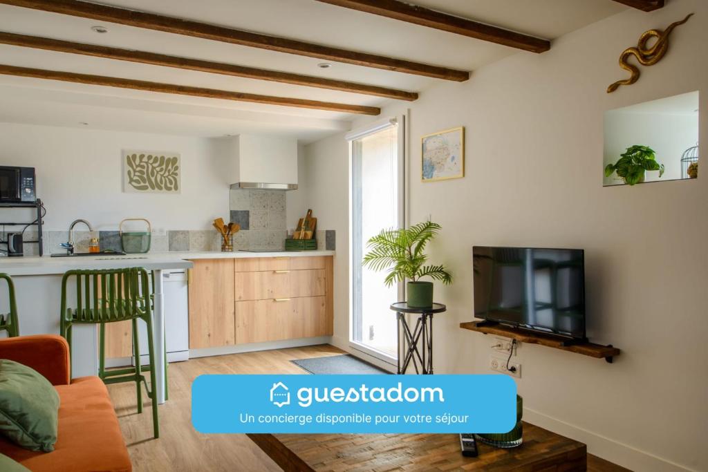 a living room with a tv and a kitchen at L'Orka - 15mn aéroport Nantes - Wifi in Saint-Léger-les-Vignes