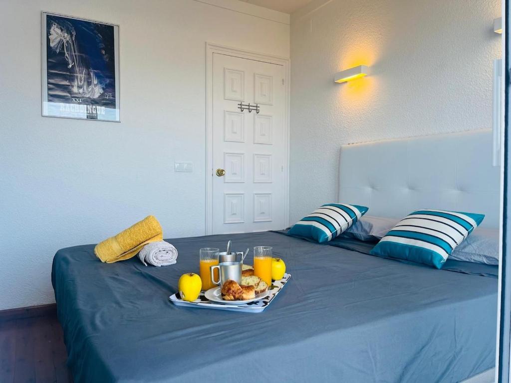 a tray of food on a bed with orange juice at Costa Brava - Roses - Terrace & sea view in Roses