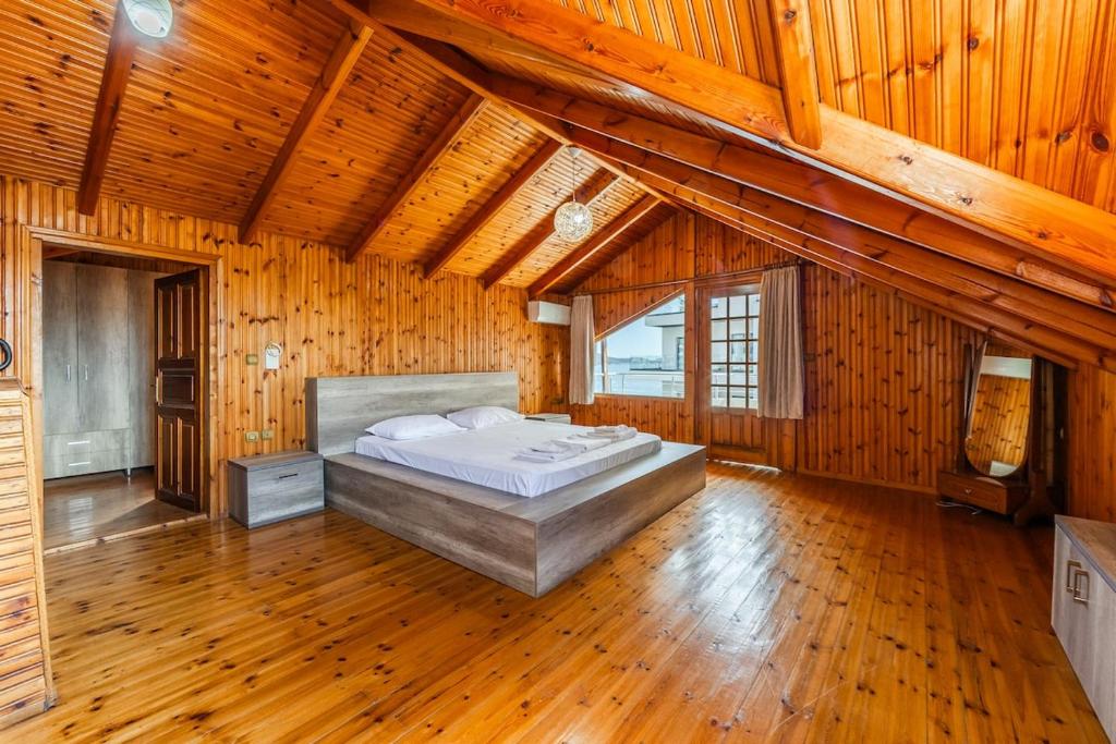 a large bedroom with a bed in a room with wooden ceilings at Saranda Seaview Spot in Sarandë