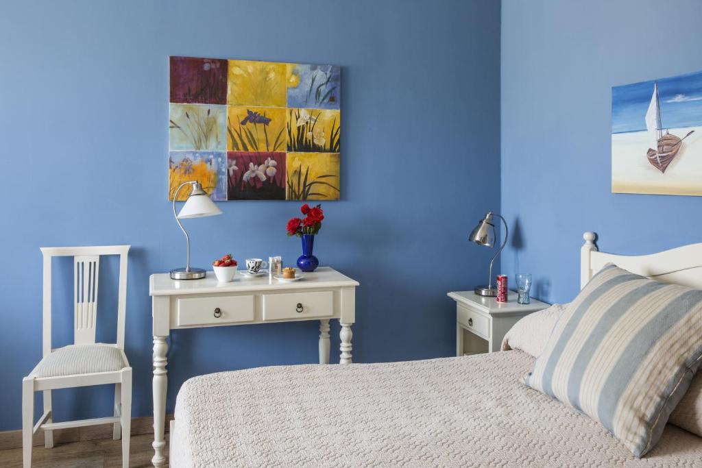 - une chambre bleue avec un lit et deux tables dans l'établissement Hotel San Pietro, à Villafranca di Verona