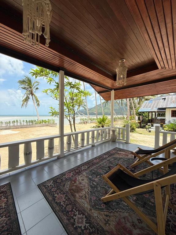 a porch with chairs and a view of the beach at Beachfront house in Chaloklum in Mae Haad