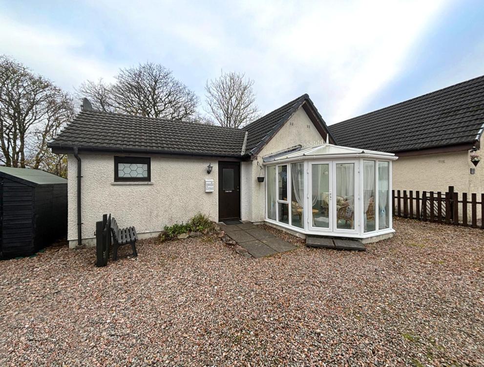 a house with a conservatory in the front of it at Craiglea Cottage in Fort William