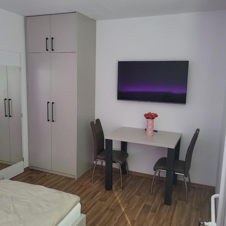 a room with a table with chairs and a tv on the wall at Apartment for 2 people in the city center in Hradec Králové