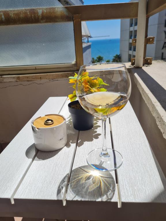都拉斯Sara-El Seaside Apartment Durres的坐在阳台上的桌子上,用葡萄酒杯