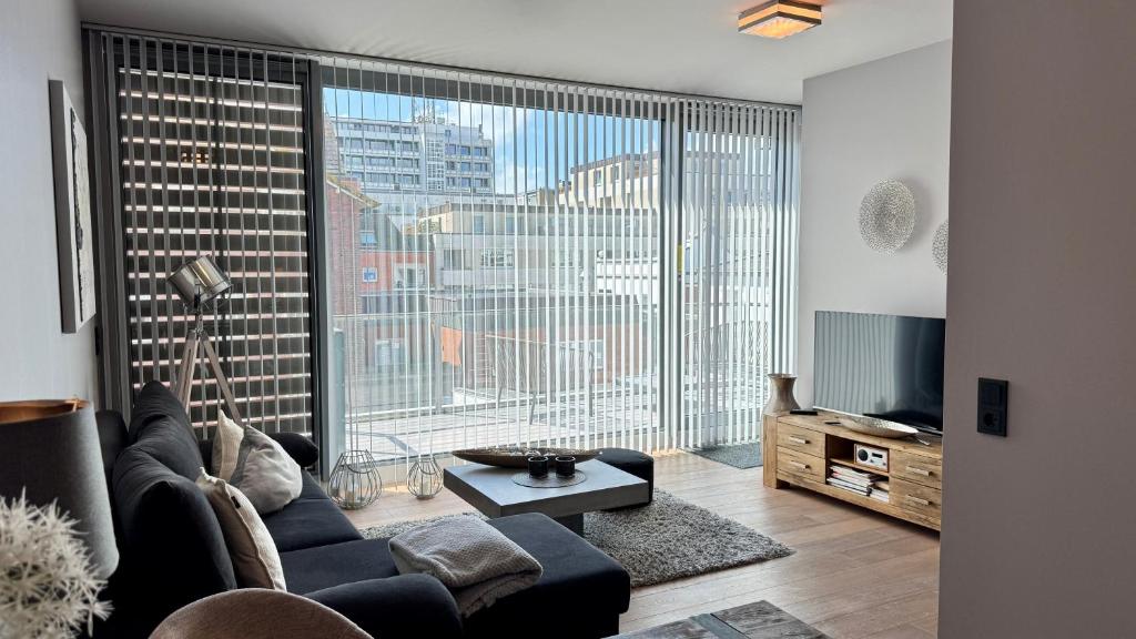 un soggiorno con un divano e una grande finestra di CityLounge a Westerland