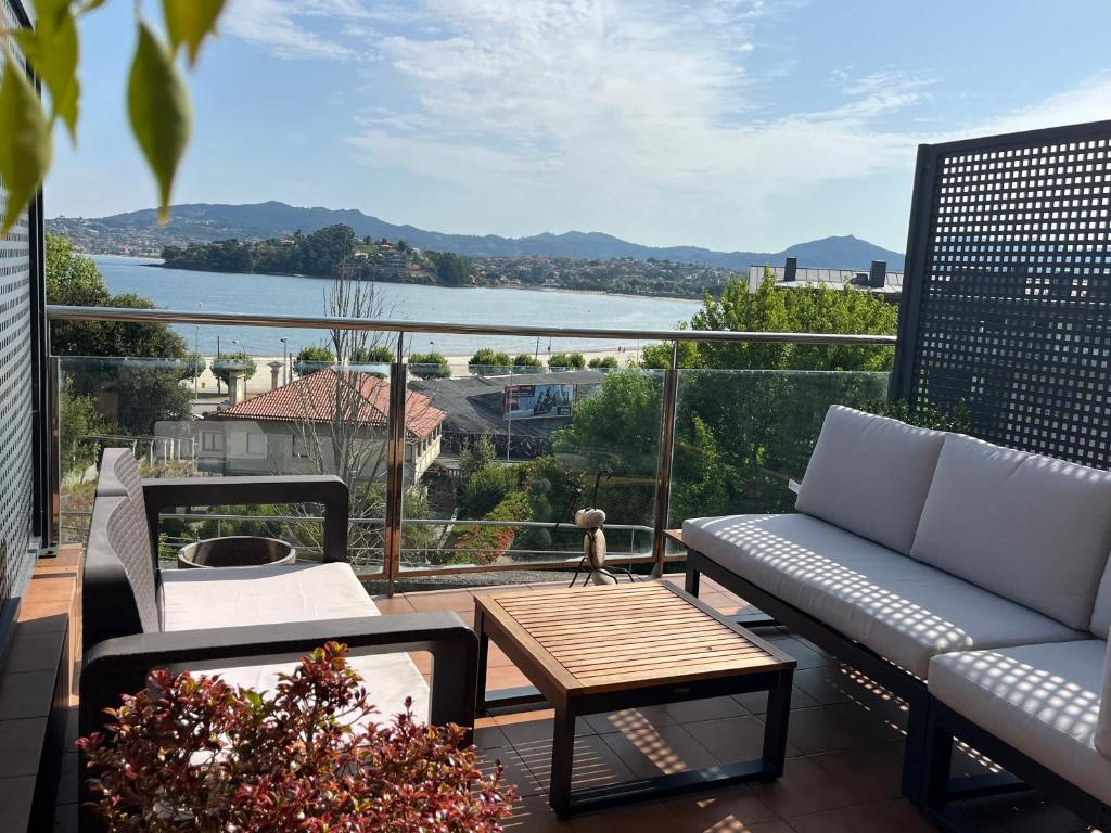 d'un balcon avec des canapés et une vue sur l'eau. dans l'établissement Apartamento en Baiona a 200m de la playa, à Baiona