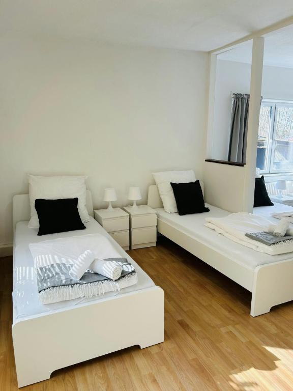 Spacious Apartment for 6 في هامبورغ: غرفة بيضاء بسريرين ومرآة