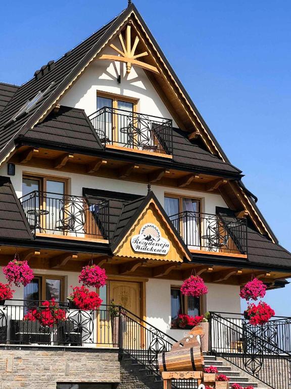 a building with flowers on the balconies of it at Rezydencja Widokowa in Bukowina Tatrzańska