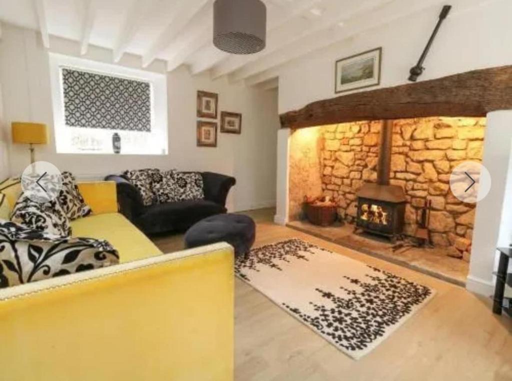 a living room with a couch and a fireplace at Broadwindsor Cottage in Broadwindsor