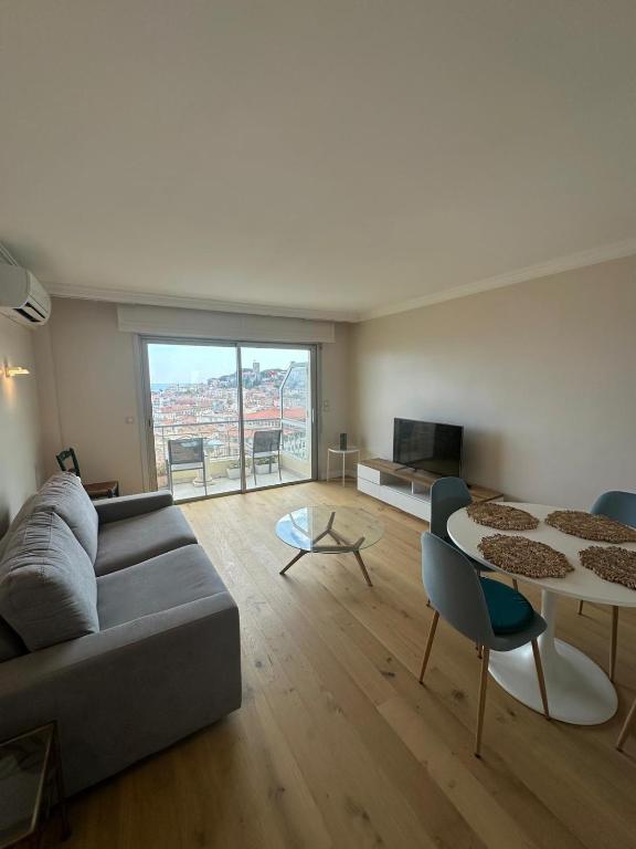 un salon avec un canapé et une table dans l'établissement Vue mer panoramique pour ce 3 pièces a 7 minutes a pied du palais du festival, à Cannes