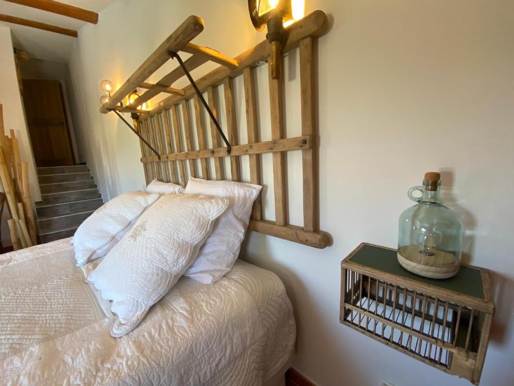 Un dormitorio con una cama con cabecero de madera. en Duo SPA Provence, en Violès