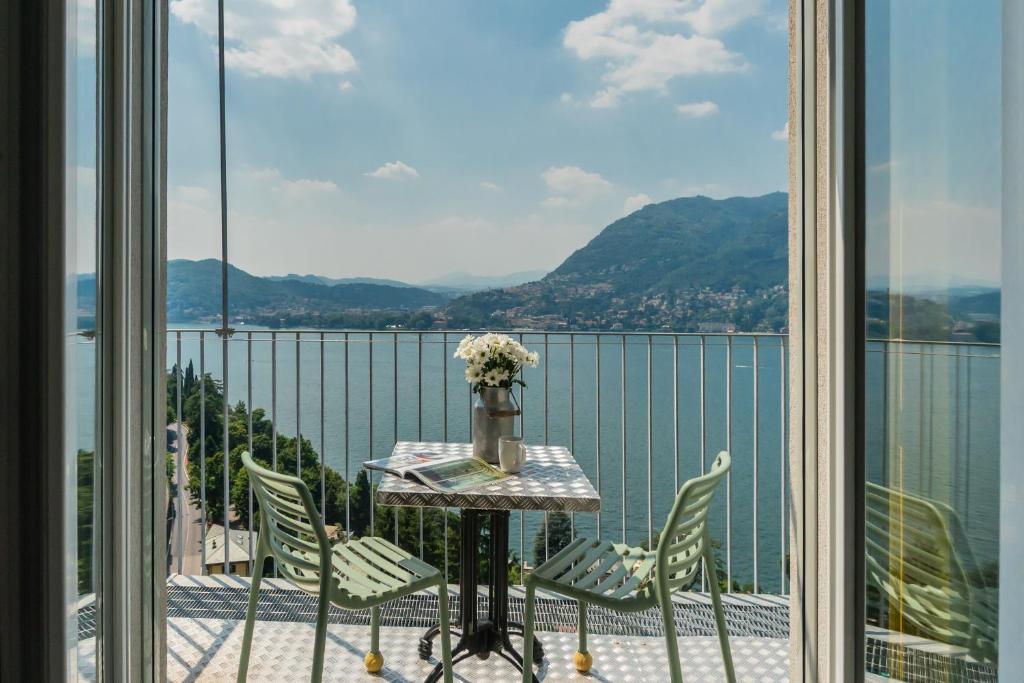 a table and chairs on a balcony with a view of the water at Casa Corbu by Rent All Como in Blevio