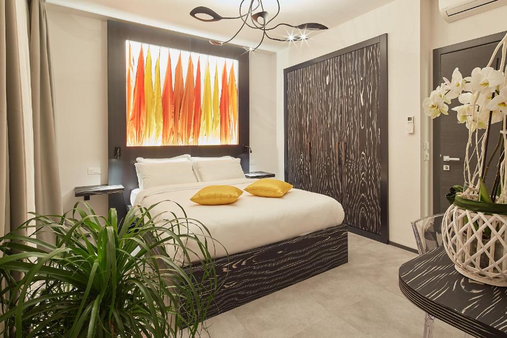 1 dormitorio con 1 cama con 2 almohadas amarillas en B&B VIA ROMA 25, en Arezzo