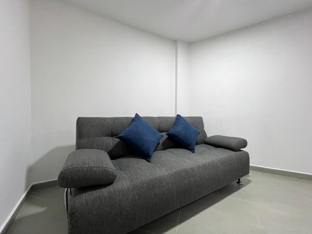 a couch with two blue pillows in a room at Apartamento Florelba - a dos cuadras del parque in Carmen de Viboral